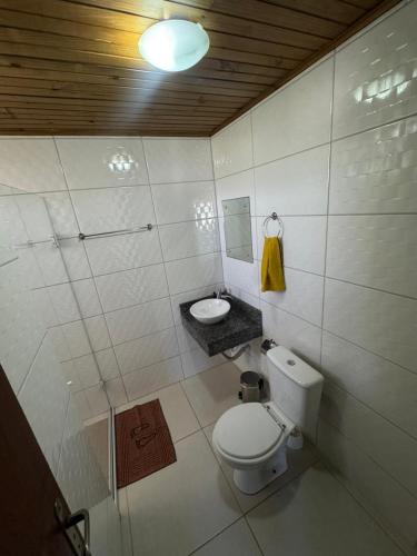 a small bathroom with a toilet and a sink at Pousada Mahara - Praia do Rosa in Imbituba