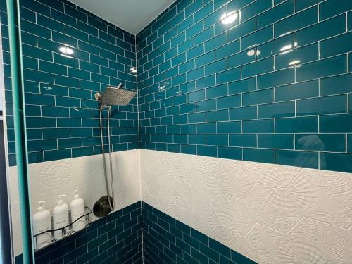 a blue tiled bathroom with a shower with blue tiles at Romantic Guest House · Heated Spa & Pool · Private Retreat in Fort Lauderdale