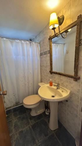 a bathroom with a sink and a toilet and a mirror at Complejo Pueblo del Sol in Piriápolis