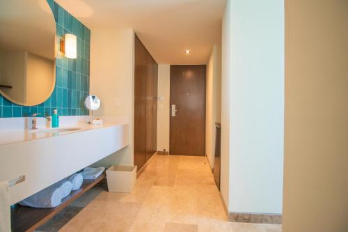a bathroom with a sink and a mirror at Hotel Casa Bahía Cozumel - Adults Only in Cozumel
