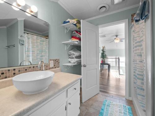 a bathroom with a sink and a large mirror at No Work Zone in North Topsail Beach