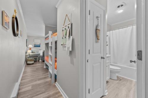 a white bathroom with a toilet and a sink at Feel the Sea Breezes in North Topsail Beach