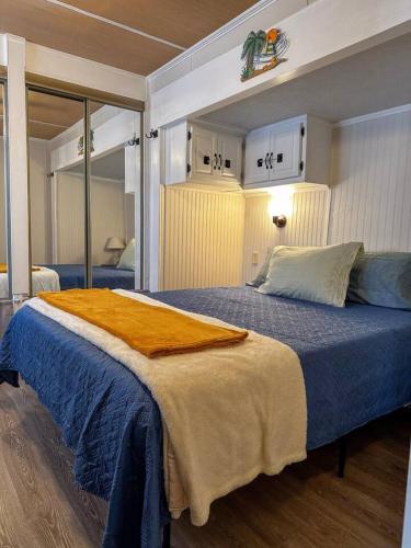 a bedroom with a bed with a blue blanket on it at The Salty Camper in North Topsail Beach