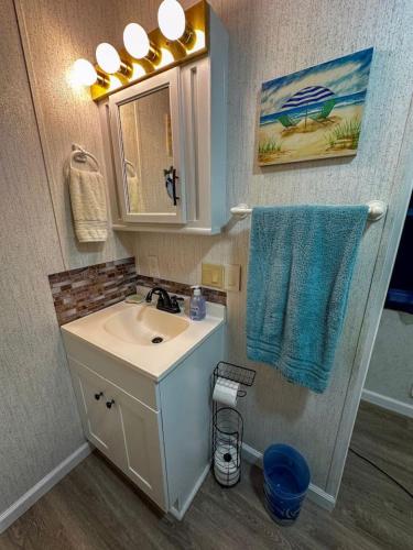 a bathroom with a sink and a blue towel at The Salty Camper in North Topsail Beach