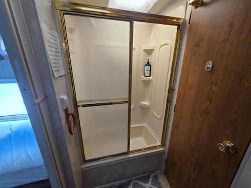 a glass shower door with a bottle inside of it at Cozy Camper NTB in North Topsail Beach