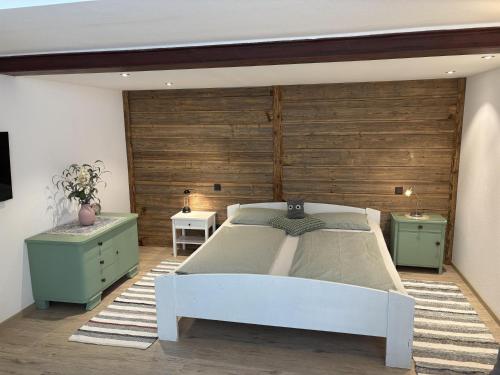 a bedroom with a white bed and two tables at Ferienwohnung am Kienbach in Herrsching am Ammersee