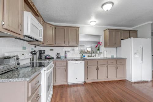a kitchen with white appliances and wooden cabinets at Denver Retreat in Arvada