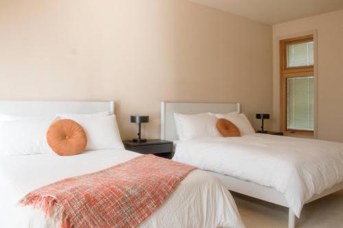 two beds with orange pillows in a bedroom at Quiet Private Room with Ensuite Free Parking in Victoria