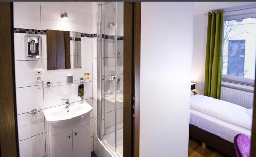 a bathroom with a sink and a shower at Hirsch Hotel Hanau in Hanau am Main