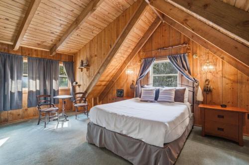 a bedroom with a bed in a room with wooden walls at Townsend Charm: River View Historic Log Cabin! in Townsend