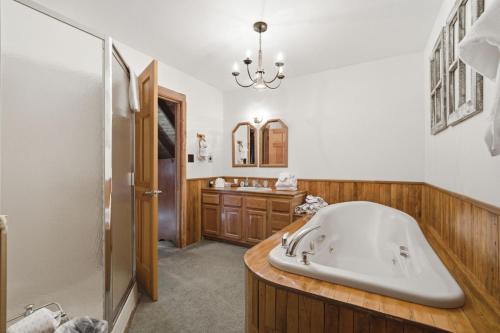 a large bathroom with a tub and a sink at Townsend Charm: River View Historic Log Cabin! in Townsend
