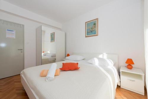 a white bedroom with two beds and a mirror at Room Peričić in Strožanac