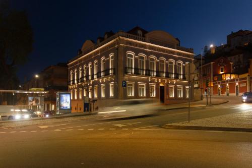 a building on a city street at night at Casa dos Aromas - Heritage & Comfort - ApartHotel in Coimbra