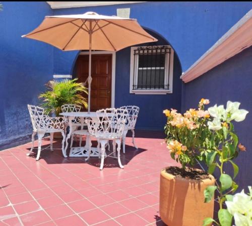 a table and chairs with an umbrella on a patio at Casa Refugio Budget House 8 Rooms & 9 Bathrooms in Oaxaca City