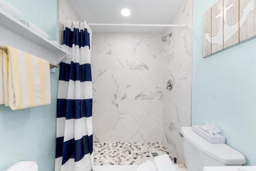 a bathroom with a white and blue shower curtain at Star Fish 3 Bed 2 bath POOL Walk to Beach in Sarasota