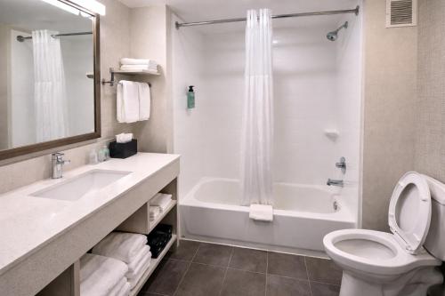 a bathroom with a toilet and a tub and a sink at Best Western Cy-Fair in Houston