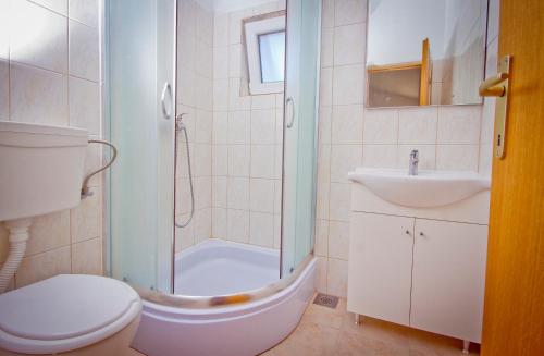 a bathroom with a shower and a toilet and a sink at Apartment Mara in Primošten