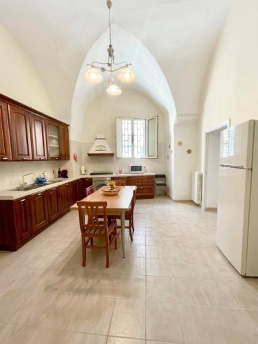 a large kitchen with a table and a white refrigerator at Mercanti in Manduria