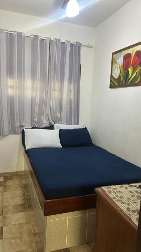 a small bed in a room with a window at Aconchegante casa piuma in Piúma