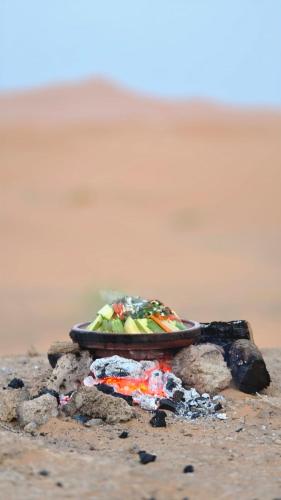 a plate of food sitting on the beach at Morocco desert camp in Merzouga