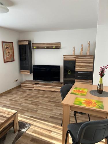 a living room with a table and a television at Apartmán Studničky v centre Žiliny in Žilina