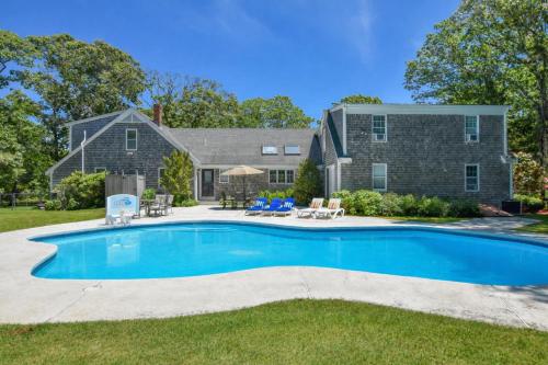 a swimming pool in front of a house at Private pool 3 mins to Skaket Beach in Orleans