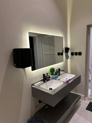 a bathroom with a sink and a mirror at شقة اند هوم in Hail