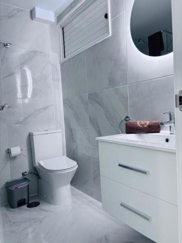 a bathroom with a toilet and a sink and a mirror at Blue Ocean Costa Adeje 502 in Playa de las Americas