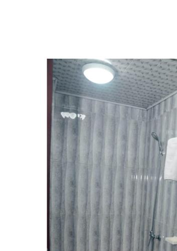 una doccia in un bagno con una tenda da doccia di Ngueye Hotel a Yaoundé