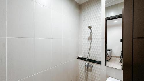 a bathroom with a toilet and a mirror at Lee Simple House - Summarecon Bandung in Tegallebu