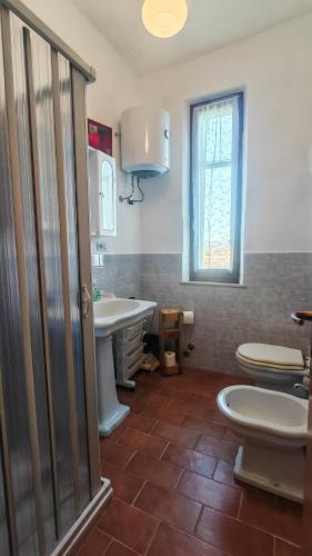 a bathroom with a toilet and a sink at Casa Algherini in Borghetto