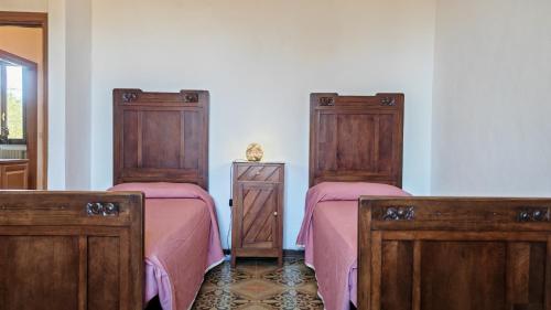 two beds in a room with pink sheets at Casa Algherini in Borghetto