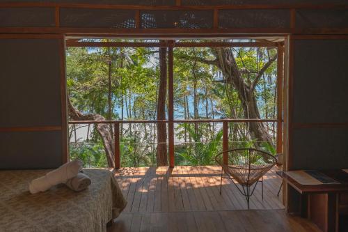 a room with a bed and a large window at Los Vivos Beachfront Experience in Pochote