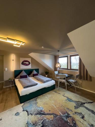 a bedroom with a large bed and a table at One Seven - BRIGHT Collection in Koblenz