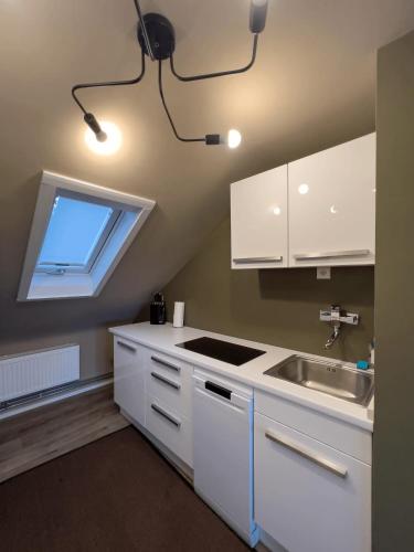 a kitchen with white cabinets and a sink and a window at One Seven - BRIGHT Collection in Koblenz