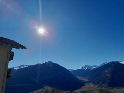 a sun in the sky over a mountain range at Hofschank Reinalterhof in Malles Venosta