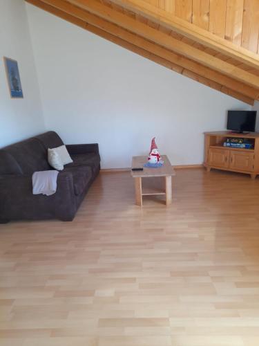 a living room with a black couch and a table at Hofschank Reinalterhof in Malles Venosta