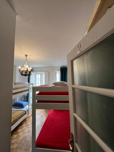a bedroom with a bunk bed and a red rug at Arcanjo Hostel 2 in Braga