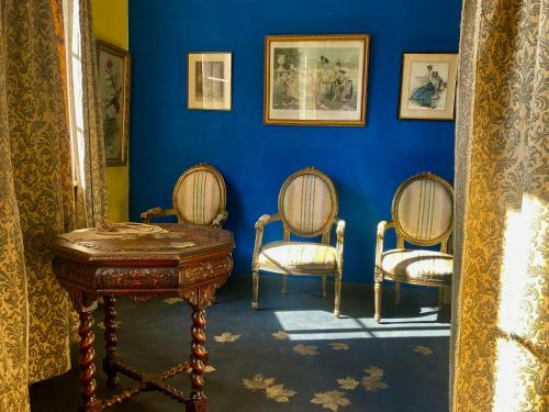 a room with two chairs and a table and a blue wall at Oranienburg Vintage Hotel - Private Garden Residence in Vianden