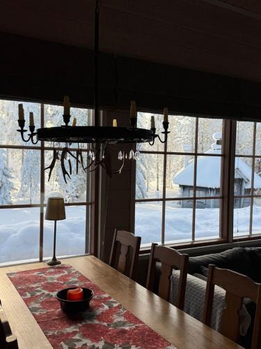 a dining room table with a chandelier in front of a window at Ailo Iso-Syöte in Pudasjärvi