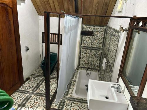 a bathroom with a sink and a shower and a tub at Kuyas Tree House in Puerto Princesa City