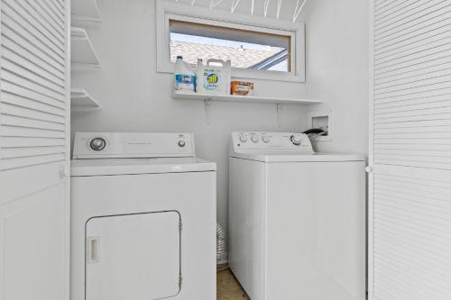 a small kitchen with a white stove and a washer at Waldo Craftsman - Fenced yard Walkable to dining in Kansas City