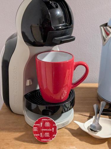 a coffee maker with a red cup on a counter at The Unicorn Inn in Richmond