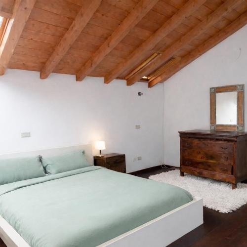 a bedroom with a green bed and a wooden ceiling at Casa di Cocco in Alzano Lombardo