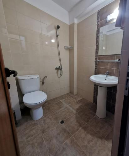 a bathroom with a toilet and a sink at Хотел Магура in Rabisha
