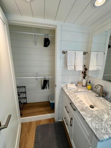 a white bathroom with a sink and a shower at Horseshoe Tiny home in Scottsdale