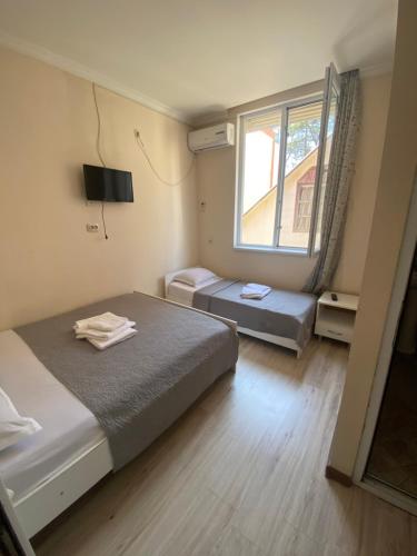 a small bedroom with two beds and a window at Barakat Hotel in Ureki