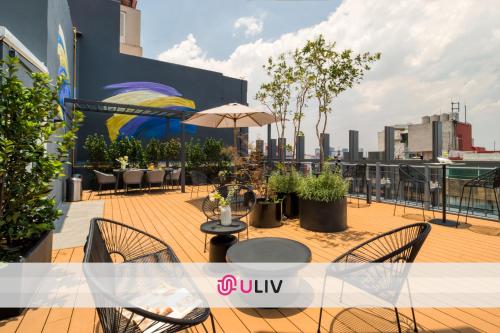a balcony with tables and chairs on a building at ULIV Parque Lincoln in Mexico City