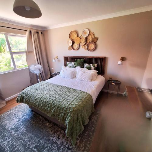 a bedroom with a large bed with a green blanket at Weekend at Bernies in Pringle Bay