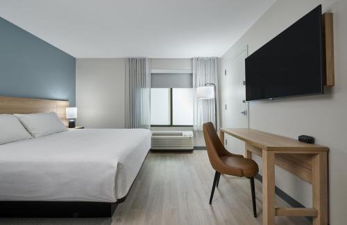 a hotel room with a bed and a desk and a tv at Hyatt Studios Texarkana in Texarkana